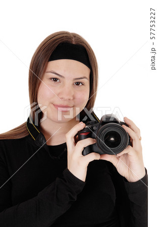 Teen girl holding a camera and taking pictures Teen girl holding a camera and taking pictures 57753227