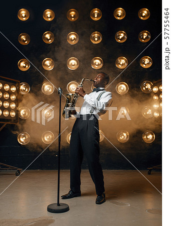 Male jazzman plays the saxophone on stage Male jazzman plays the saxophone on stage 57755464