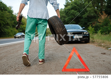 Car breakdown, man puts the spare tyre Car breakdown, man puts the spare tyre 57755806