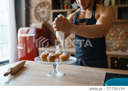 Nude man in apron cooking dessert on the kitchen 57756134