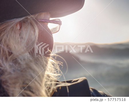 Young blond hair hiker sitting on cliff and enjoy  57757518