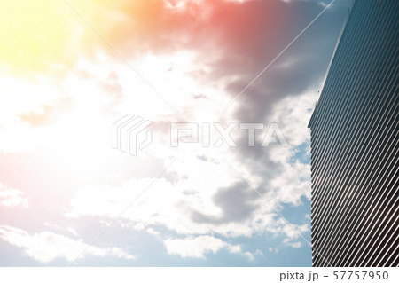 Corrugated metal wall against bright sunny sky with white clouds Corrugated metal wall against bright sunny sky with white clouds 57757950