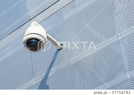 Close-up of surveillance camera on white metal surface with a lot of tiny round openings Close-up of surveillance camera on white metal surface with a lot of tiny round openings 57758791