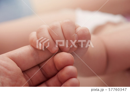Baby hold mom finger 57760347