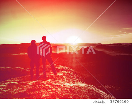 Silhouette woman and man at sunset on top Silhouette woman and man at sunset on top 57766160