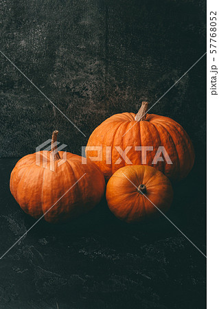 Photo of three orange pumpkins on black background, halloween celebration. 57768052