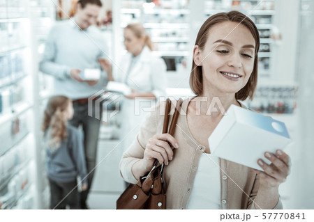 A spouse reading the pills prescription near the drugstore window 57770841