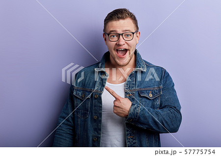Young handsome excited cheerful man showing copy space 57775754