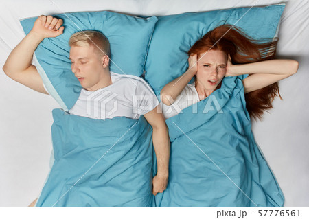 blonde man snoring and angry ginger woman cannot sleep. blonde man snoring and angry ginger woman cannot sleep. 57776561