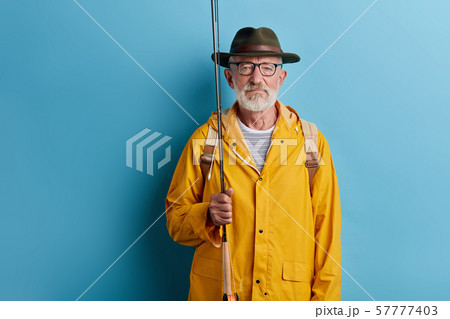 old fisherman with fishing rod and fishing gear. 57777403