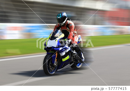 Racer on a sports bike rides on the race track Racer on a sports bike rides on the race track 57777415