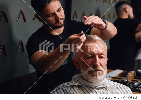 young man brushing old man's gray hair 57777423