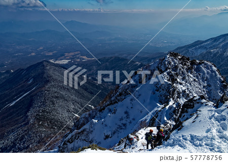 八ヶ岳連峰・赤岳山頂から下山する登山者と甲府盆地・富士山の眺め 八ヶ岳連峰・赤岳山頂から下山する登山者と甲府盆地・富士山の眺め 57778756