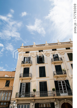 マヨルカ島の街並み　紺色の遮光扉の付いた窓のある薄クリーム色の建物 57783009