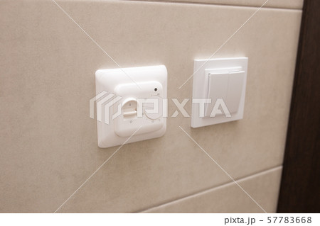 White temperature controller of a warm floor on a gray wall. 57783668