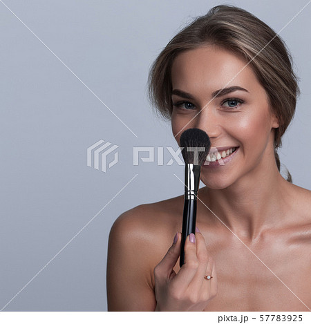 Woman holding makeup brush Woman holding makeup brush 57783925