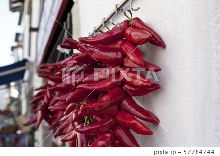 Red peppers hanging at the front of a grocery 57784744