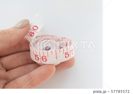 Woman hold soft body measuring tape with Woman hold soft body measuring tape with 57785572