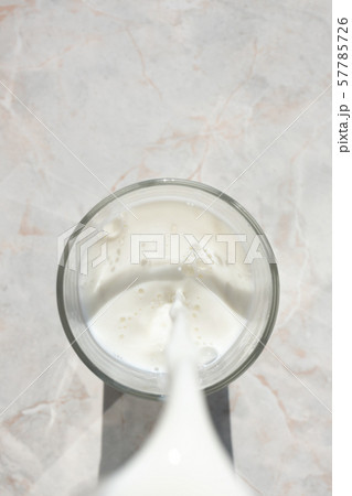 Flowing milk. Close-up of milk stream pouring into Flowing milk. Close-up of milk stream pouring into 57785726