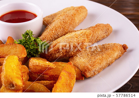 Nuggets from fish with tomato sauce and French fries Nuggets from fish with tomato sauce and French fries 57786514