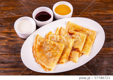 Pancakes with oil and sour cream, jam and honey Pancakes with oil and sour cream, jam and honey 57786721