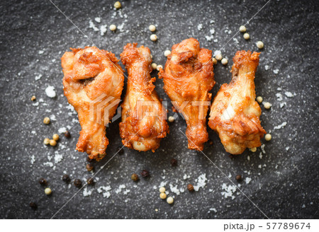 Fried chicken wings on black plate with salt herbs Fried chicken wings on black plate with salt herbs 57789674