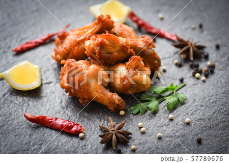 Fried chicken wings on black plate with lemon Fried chicken wings on black plate with lemon 57789676