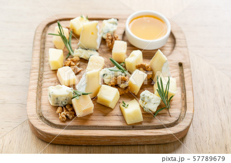Cheese plate. Delicious cheese mix with walnuts, honey on wooden table. Tasting dish on a wooden Cheese plate. Delicious cheese mix with walnuts, honey on wooden table. Tasting dish on a wooden 57789679
