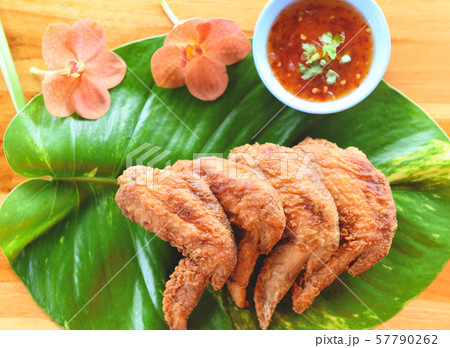 Fried chicken wings served on leaves with sauce Fried chicken wings served on leaves with sauce 57790262