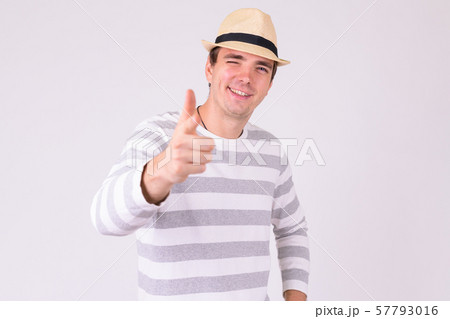 Portrait of happy tourist man winking and pointing at camera Portrait of happy tourist man winking and pointing at camera 57793016