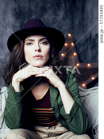 young pretty woman waiting alone in modern loft studio, fashion clothers wearing hat, lifestyle and 57793895