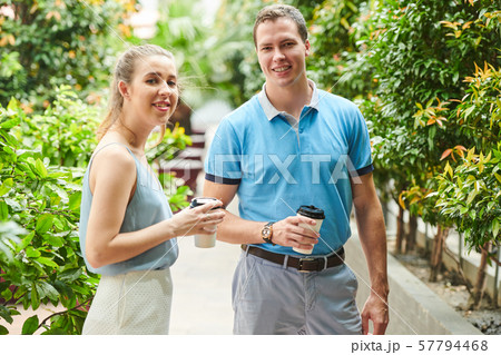 Smiling coworkers drinking coffee outdoors 57794468