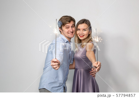 Party, fun, new year 2020, christmas and holidays concept - young happy couple with sparklers on 57794857