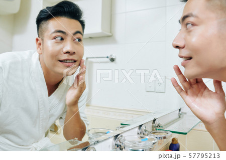 Vietnaemse man applying moisturizing lotion Vietnaemse man applying moisturizing lotion 57795213