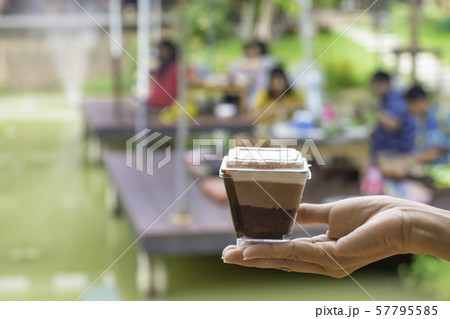 Hand holding cake Background blur people and tree in garden on pond. Hand holding cake Background blur people and tree in garden on pond. 57795585