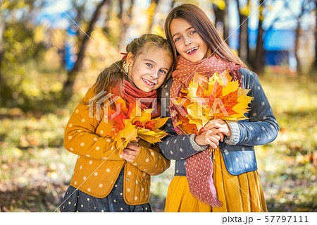 Two cute smiling 8 years old girls posing together in a park on a sunny autumn day. Two cute smiling 8 years old girls posing together in a park on a sunny autumn day. 57797111
