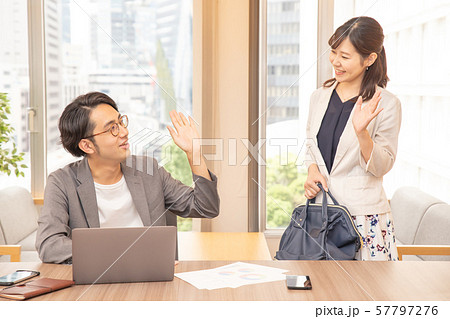 定時退勤する女性を快く送り出す男性ビジネスマン 57797276
