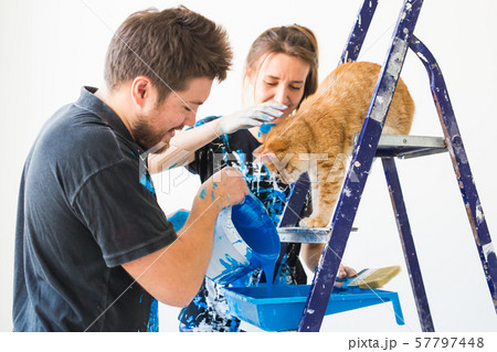 People, redecoration and renovation concept - portrait of couple with cat pour paint People, redecoration and renovation concept - portrait of couple with cat pour paint 57797448