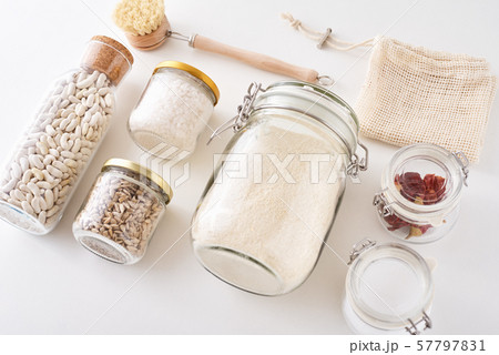 Glass jars with food ingredients on white background, top view. Zero waste concept. Kitchen background with eco friendly utensils Glass jars with food ingredients on white background, top view. Zero waste concept. Kitchen background with eco friendly utensils 57797831