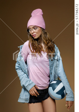 girl in jeans, a pink hat and stylish glasses with a ball 57798272
