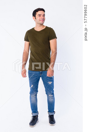 Full body of happy young handsome Persian man thinking Full body of happy young handsome Persian man thinking 57799602