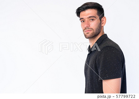 Closeup profile view of young bearded Persian man looking at camera 57799722
