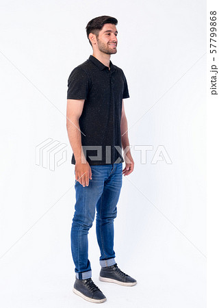 Full body shot of happy young bearded Persian man thinking 57799868