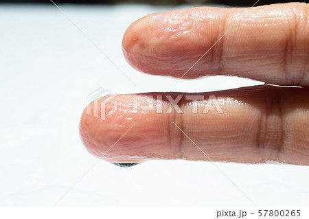 Woman's wet right hand with water drops on middle finger, White acrylic background, Close up & Macro shot, Selective focus, Asian Body skin part, Relaxing Bath, Healthcare concept Woman's wet right hand with water drops on middle finger, White acrylic background, Close up & Macro shot, Selective focus, Asian Body skin part, Relaxing Bath, Healthcare concept 57800265
