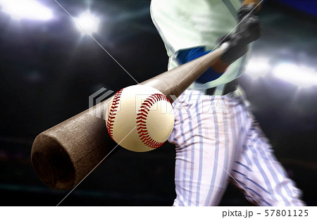 Baseball player hitting ball with bat in close up Baseball player hitting ball with bat in close up 57801125