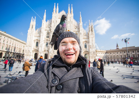 Italy, excursion and travel concept - funny guy taking selfie with pigeons in front of cathedral 57801342