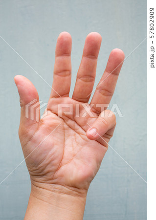 Trigger Finger lock on little finger of woman's front left hand, Suffering from pain, On Blue-grey colour background, Close up & Macro shot, Office syndrome, Health care concept Trigger Finger lock on little finger of woman's front left hand, Suffering from pain, On Blue-grey colour background, Close up & Macro shot, Office syndrome, Health care concept 57802909