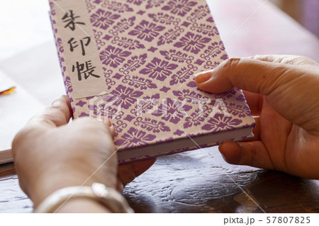 朱印帳を持つ女性の手 57807825