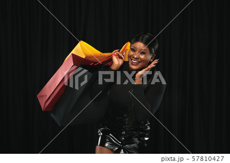Young woman in dress shopping on black background Young woman in dress shopping on black background 57810427