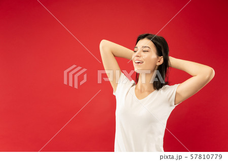 Caucasian young woman's half-length portrait on red background 57810779